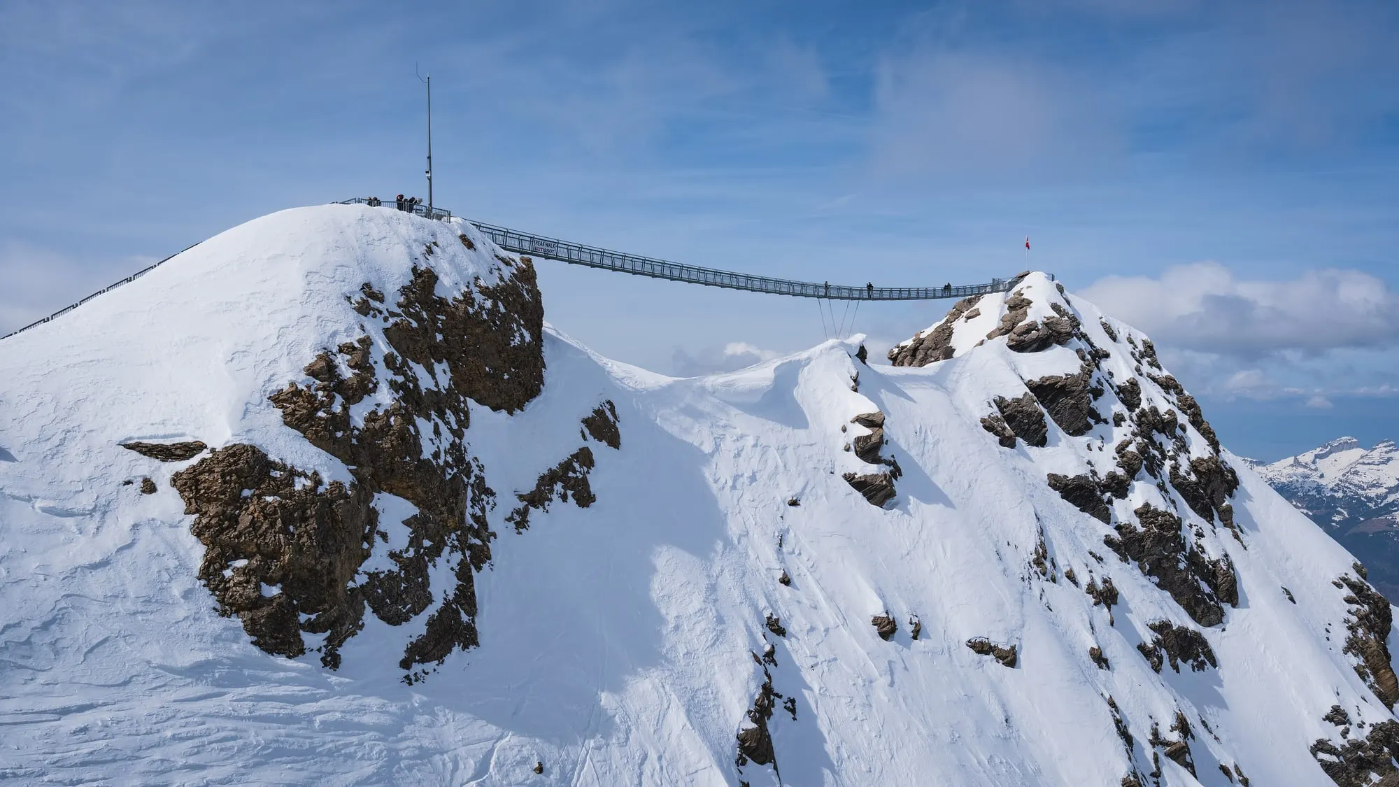 Peak Walk bridge between two snowy summits